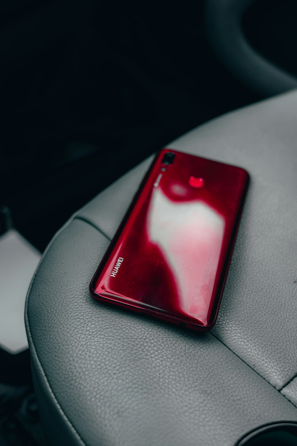 red smartphone on vehicle seat