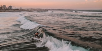 man riding surfboard under clear blue sky