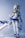 A detailed figure of an anime character with blonde hair is portrayed wearing a stylized outfit consisting of a blue and white sailor-style top and skirt, along with thigh-high stockings. The character is holding a large, ornate sword with intricate details. Antenna-like structures are part of the character's headgear, contributing to a futuristic or robotic design.