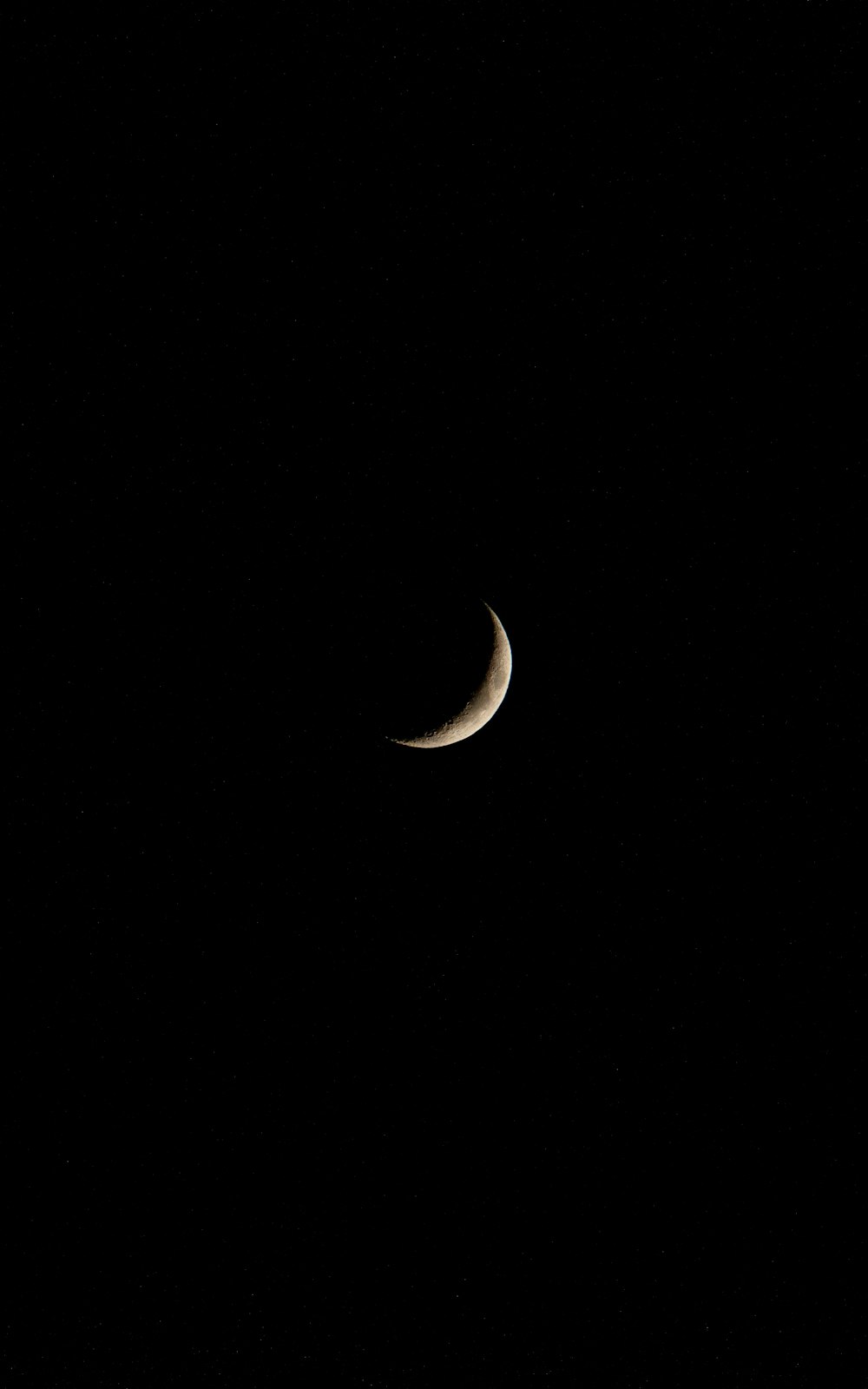 Une demi-lune est vue dans le ciel sombre