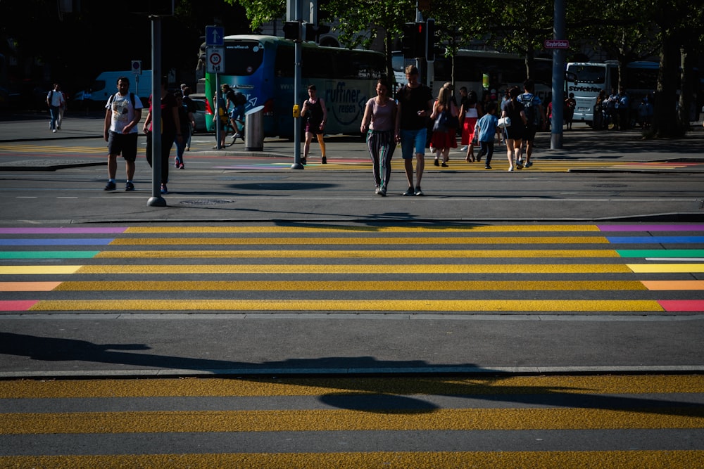 a group of people walking across a cross walk