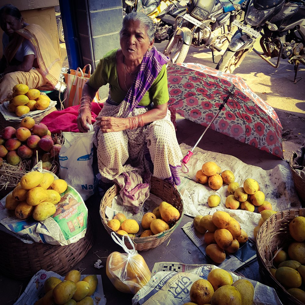 woman in dress sitting near fruits