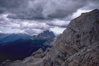 A dramatic landscape with dark clouds and distant mountains.