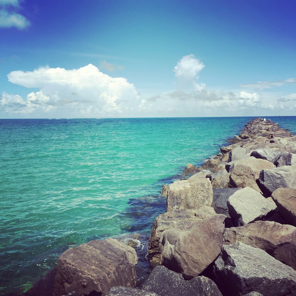 landscape photography of seawall on blue sea