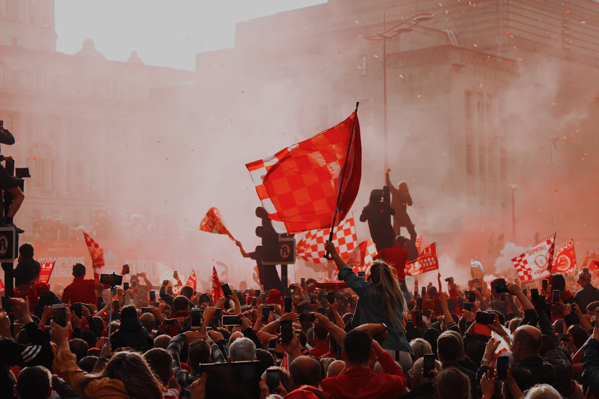 Suporter olahraga mengibarkan bendera dan bersorak meriah di tribun stadion mendukung tim favorit di turnamen AVC Champions League 2026