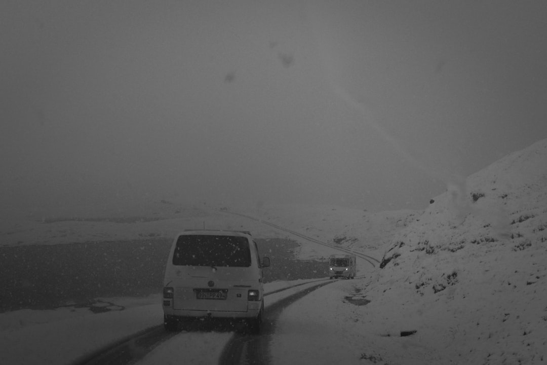 cars beside hills covered with snow