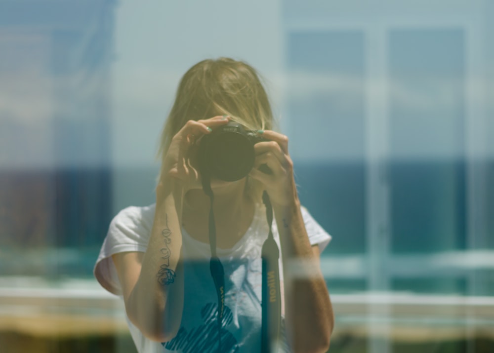 woman holding black DSLR camera