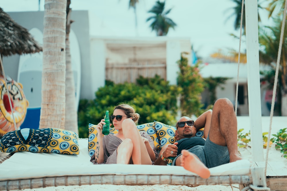 man and woman lying on lounge