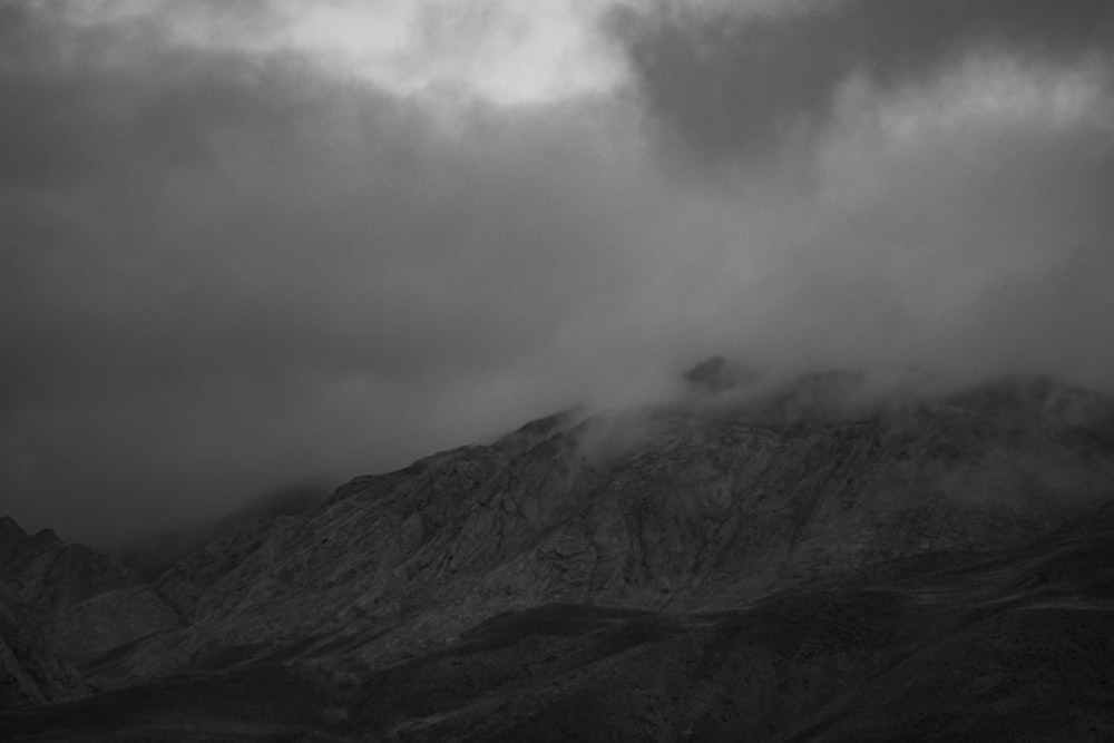 grayscale photo of foggy mountain scenery