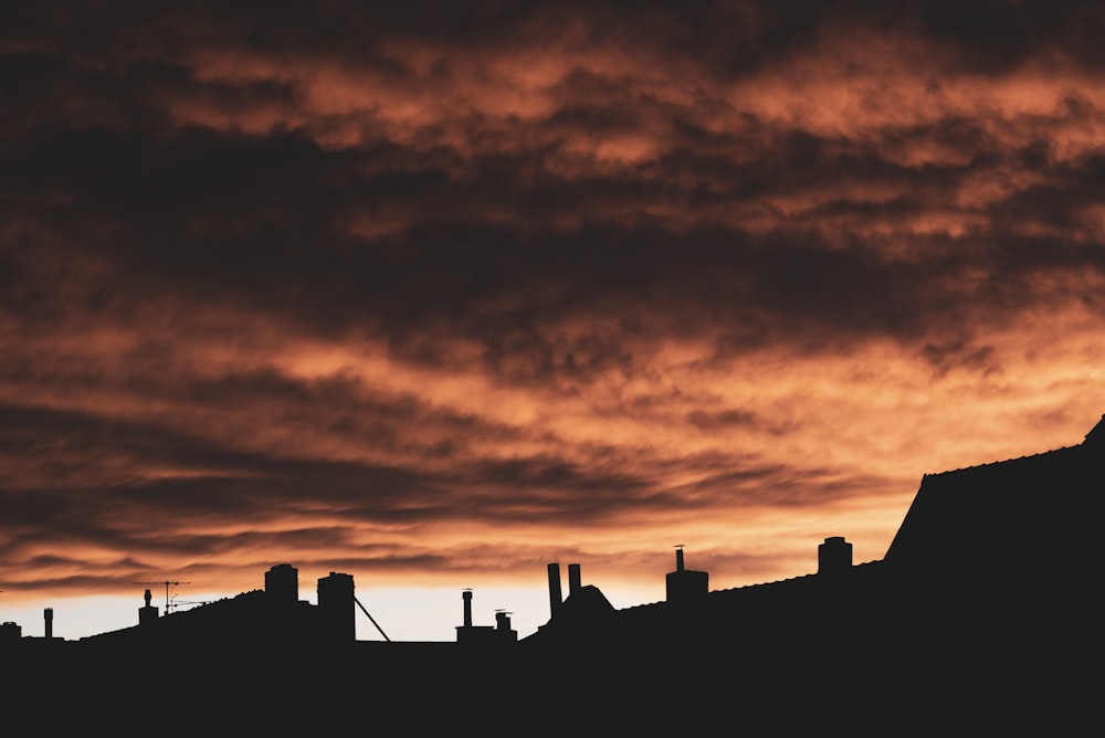 a silhouette of a building against a cloudy sky
