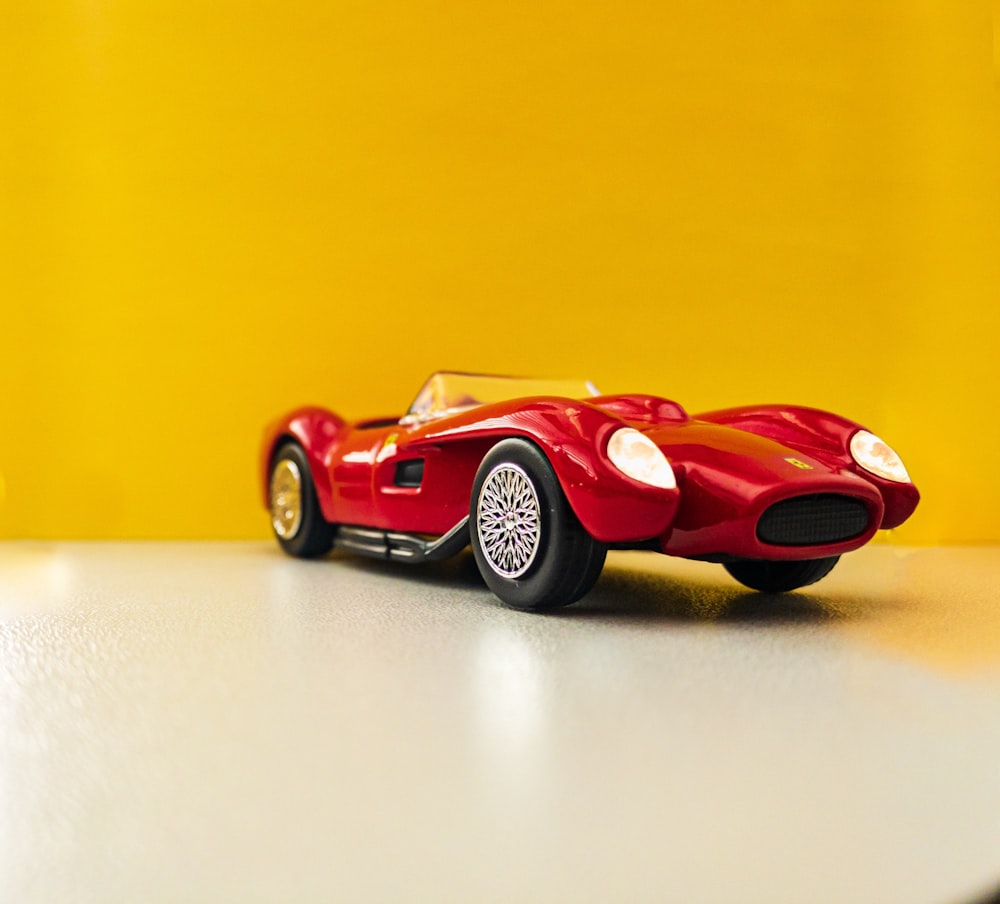 red coupe scale model on white surface