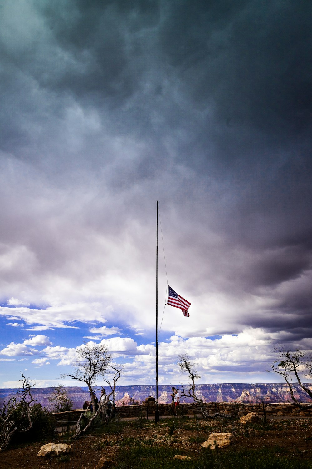 half-mast US flag under cloudy during daytime