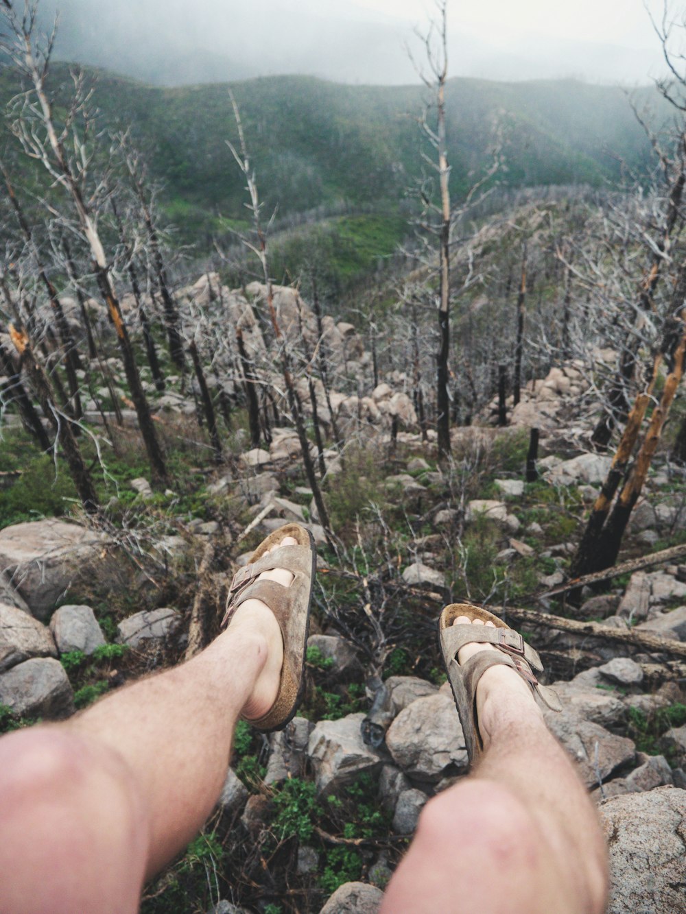 person sitting on cliff during daytime