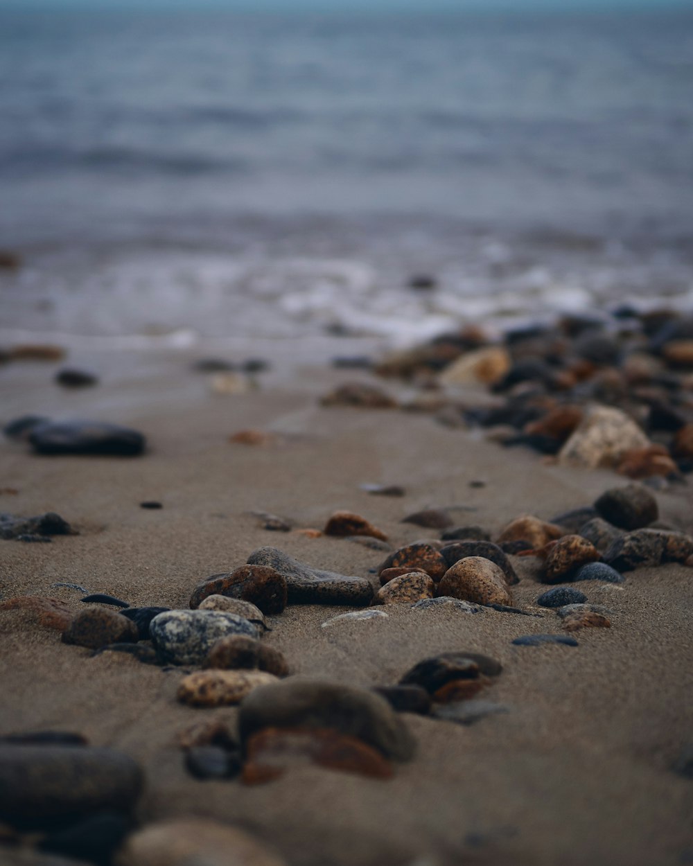 brown and black pebbles on sea shore