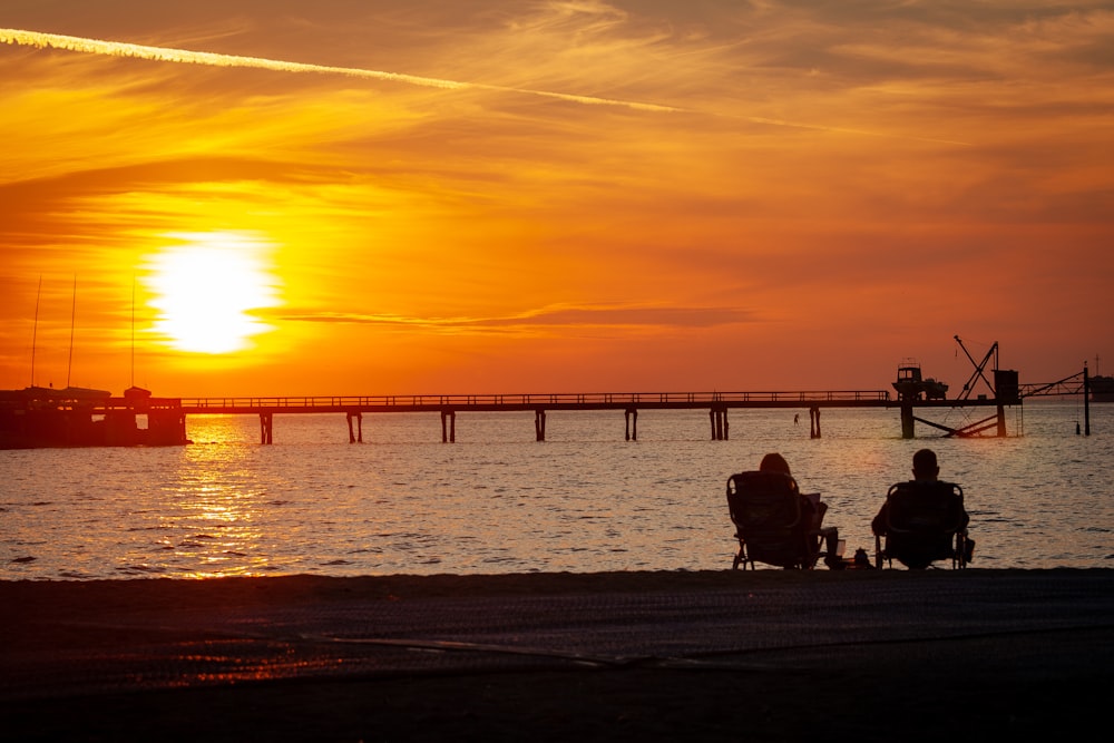 silhouette photography of couple near body of water