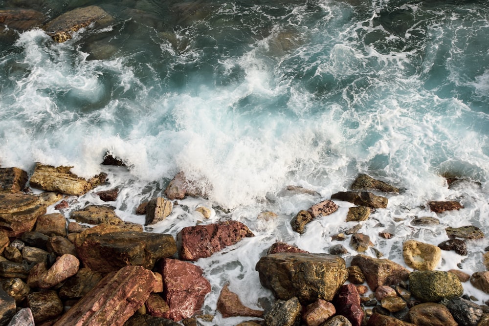 aerial photography of ocean beside rocks