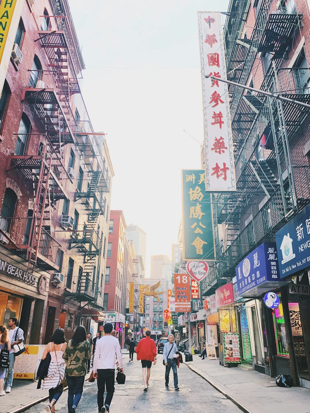 people walkinh on street between buildings with signages