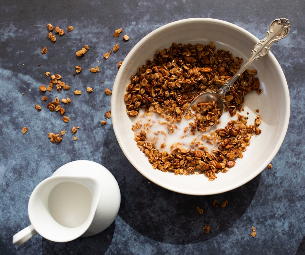 brown cereal beside pitcher of milk