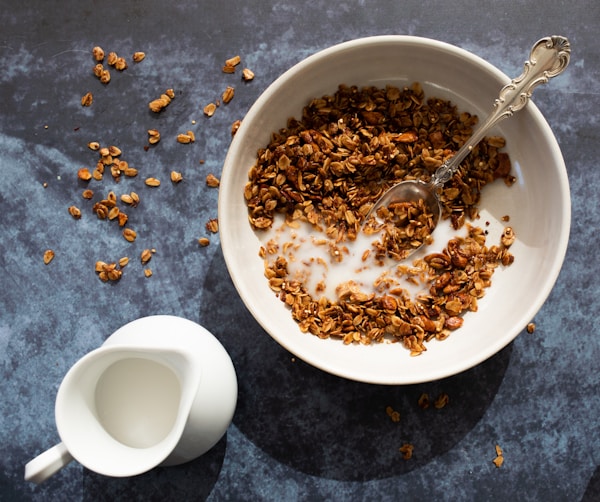 Brown cereal beside pitcher of milk