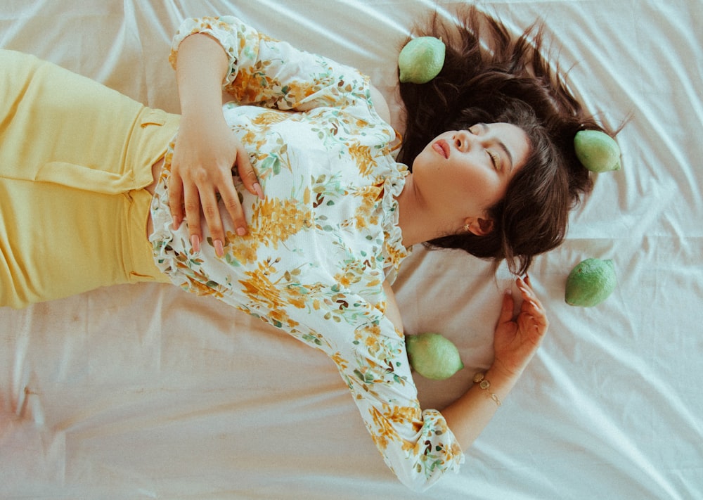 girl lying on fabric surrounded with fruits