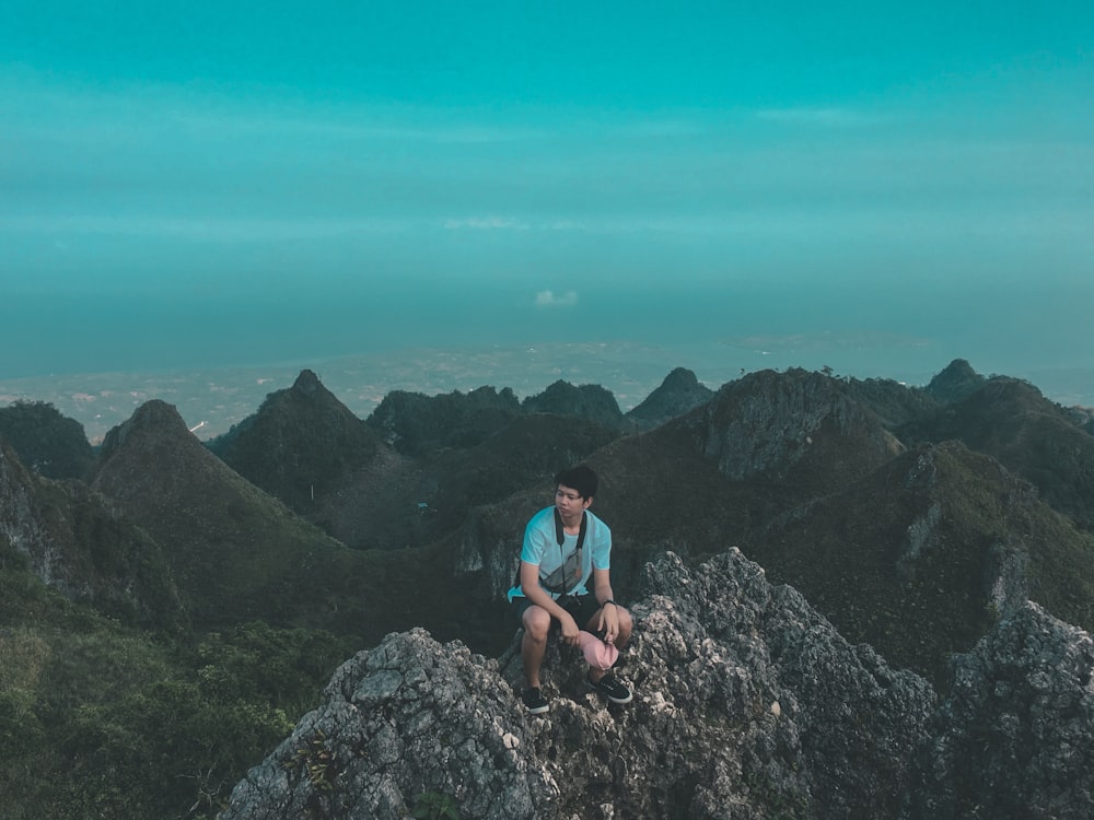 man sitting on mountain top during daytime