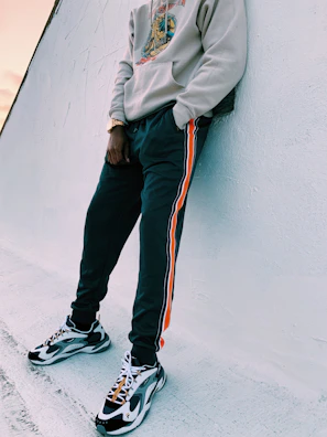 A trendy streetwear look combining a soft gold hoodie with black cargo pants in an urban setting.