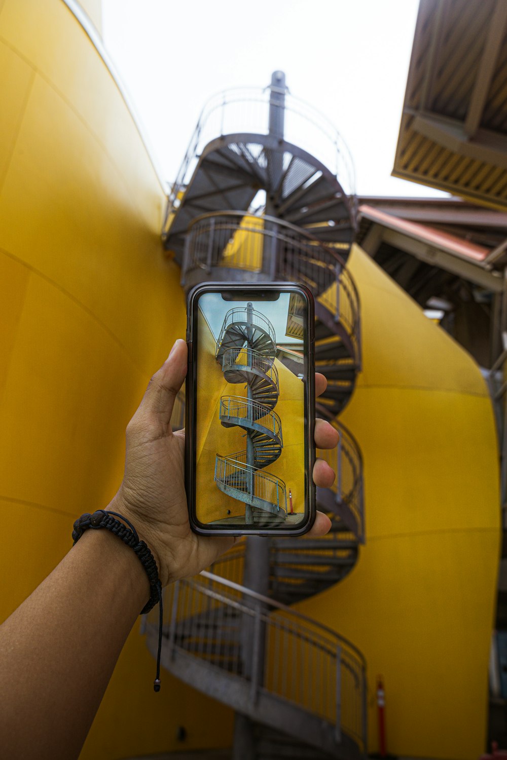 Teléfono inteligente frente a la escalera de caracol gris