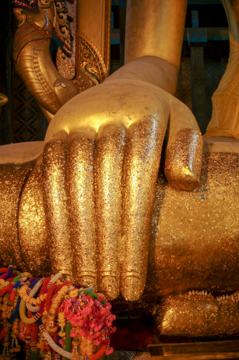 a gold statue of a hand holding a flower