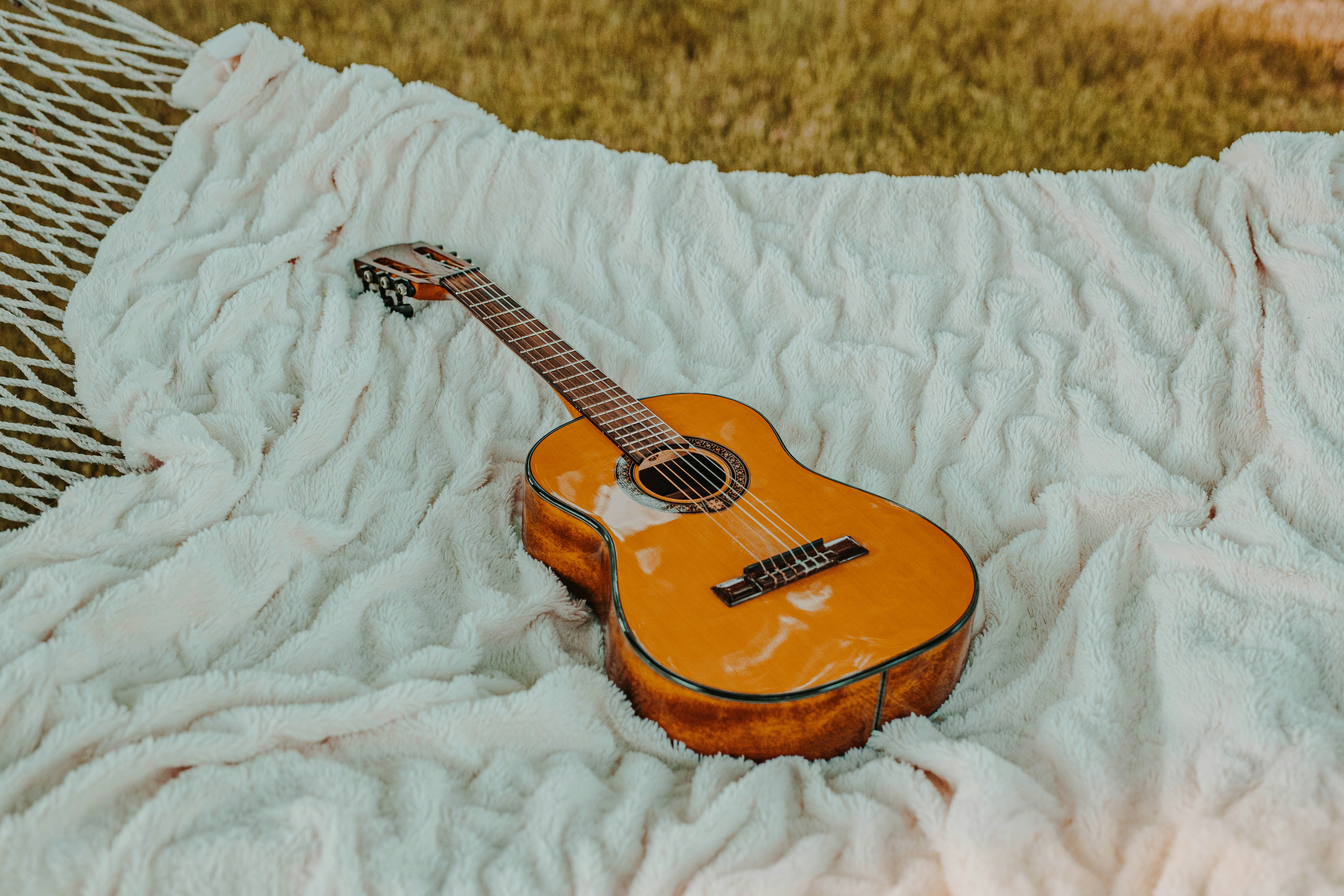 Brown classical guitar on white blanket photo – Free Usa Image on Unsplash
