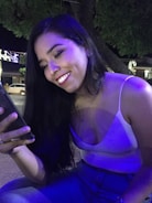 Smiling student happily interacting with daakhila ai on smartphone late at night