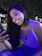 A smiling woman looking at her phone with a starry night background.