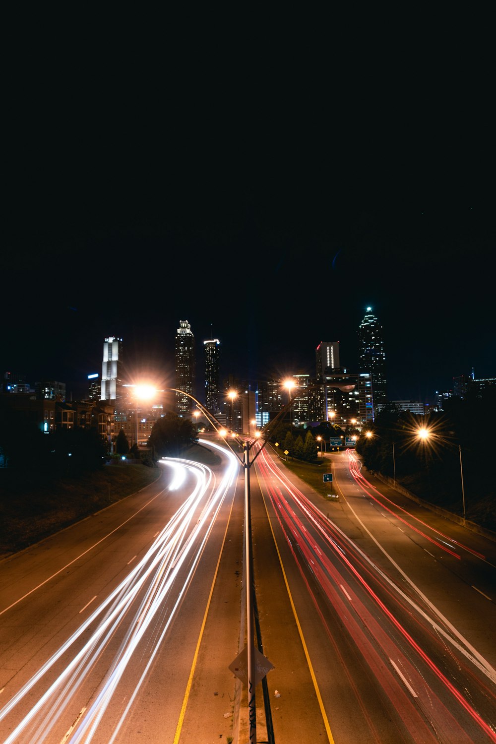 time lapse photo of cars passing by buildings during nighttime