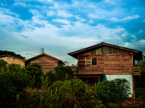 Traditional Belarusian wooden houses nestled among lush greenery under a soft sunset.