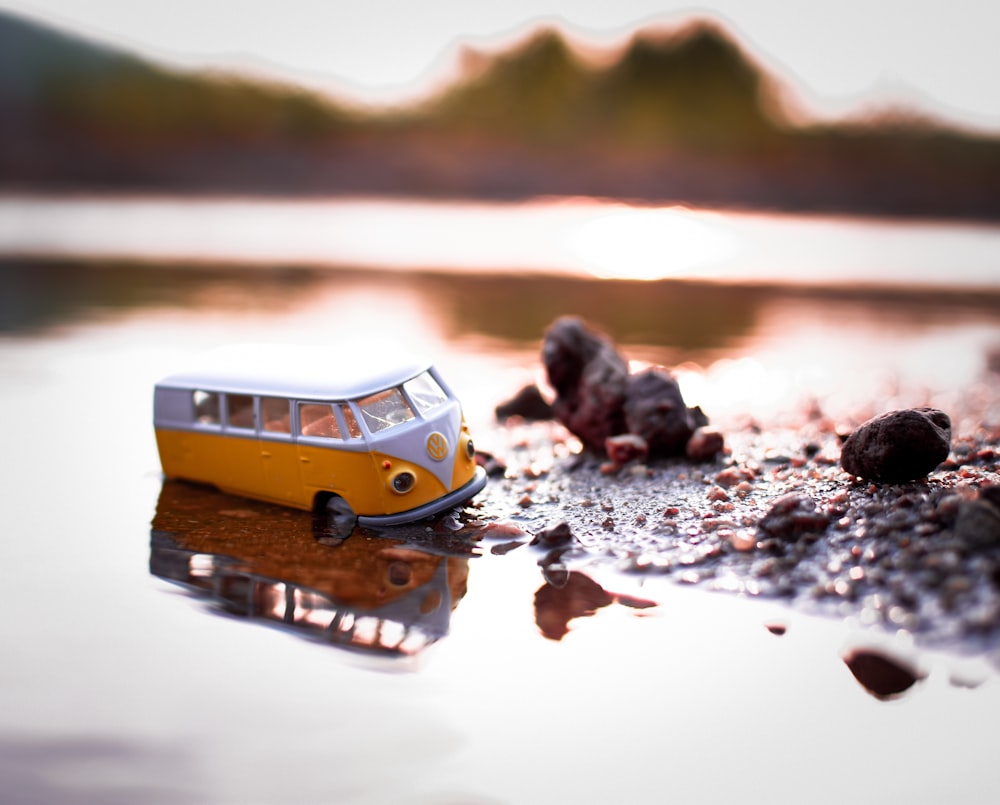 selective focus photography of yellow and white vehicle on body of water