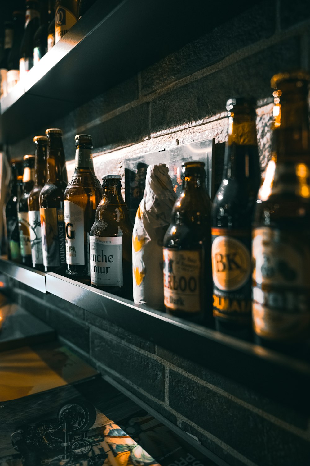 shallow focus photo of bottles on black wooden shelf