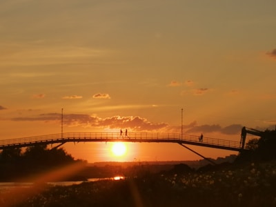 A vibrant photo of the Dom Luís I Bridge at sunset with people walking across.