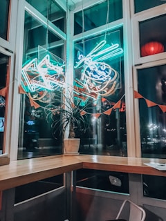 A cozy corner of Coral Bean cafe with vibrant aquariums glowing softly in the background.