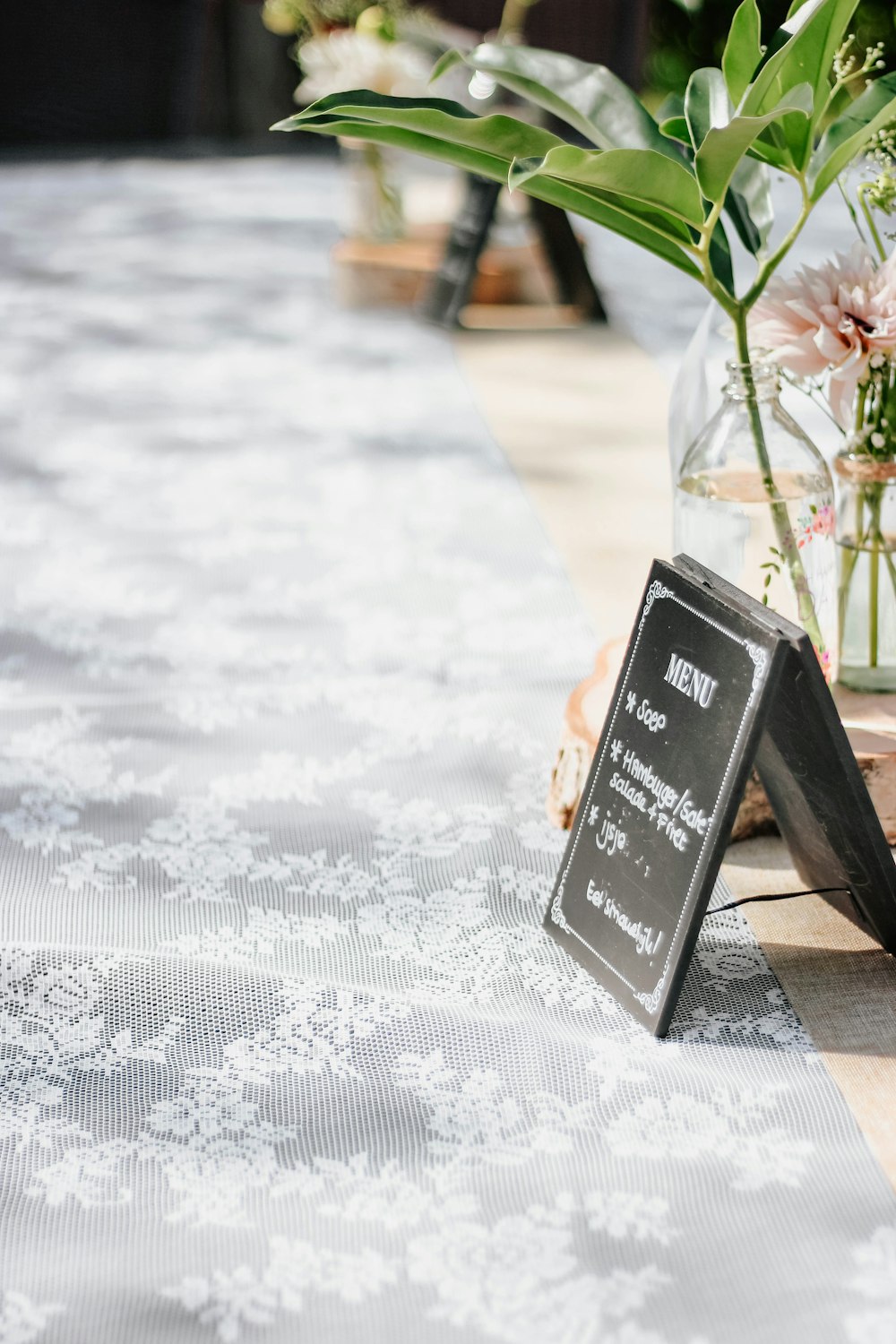 flowers in vase on white lace surface