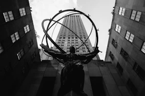 low angle photography of statue between buildings