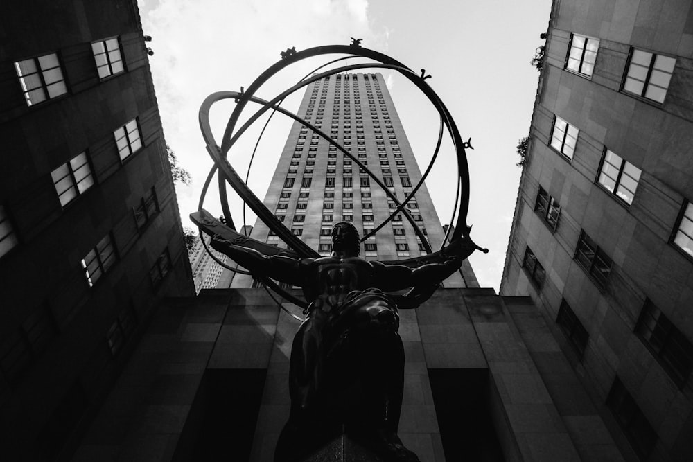Fotografía de ángulo bajo de la estatua entre edificios