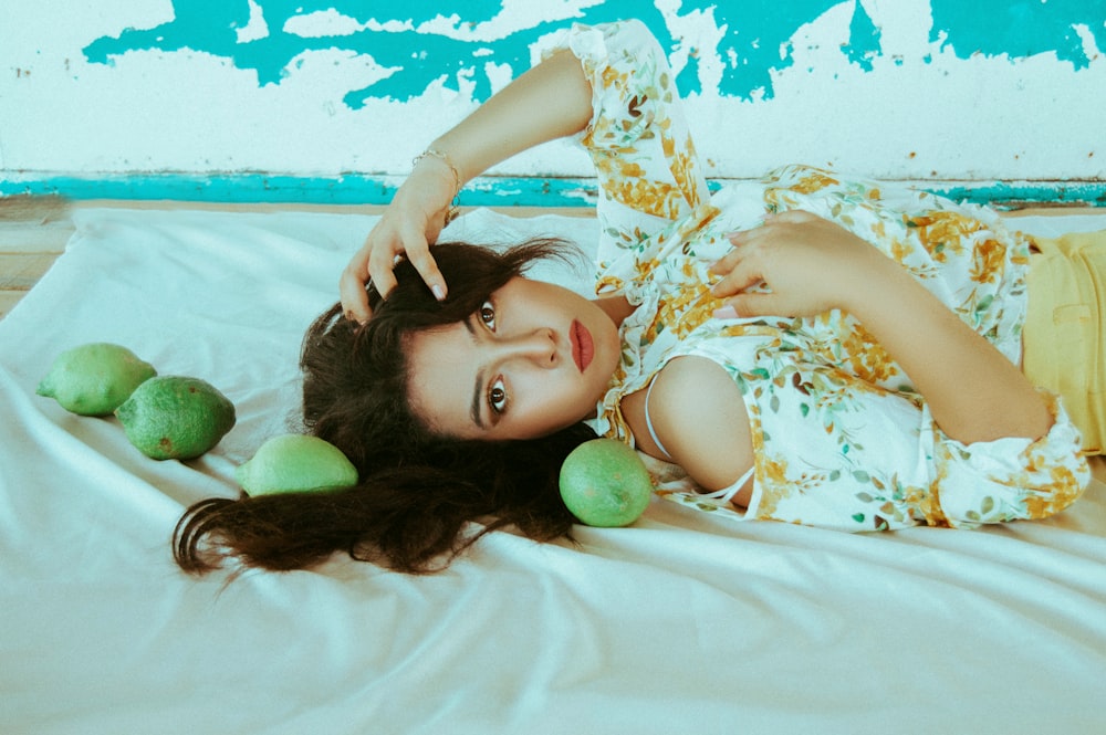 woman wearing white and brown blouse lying on white textile