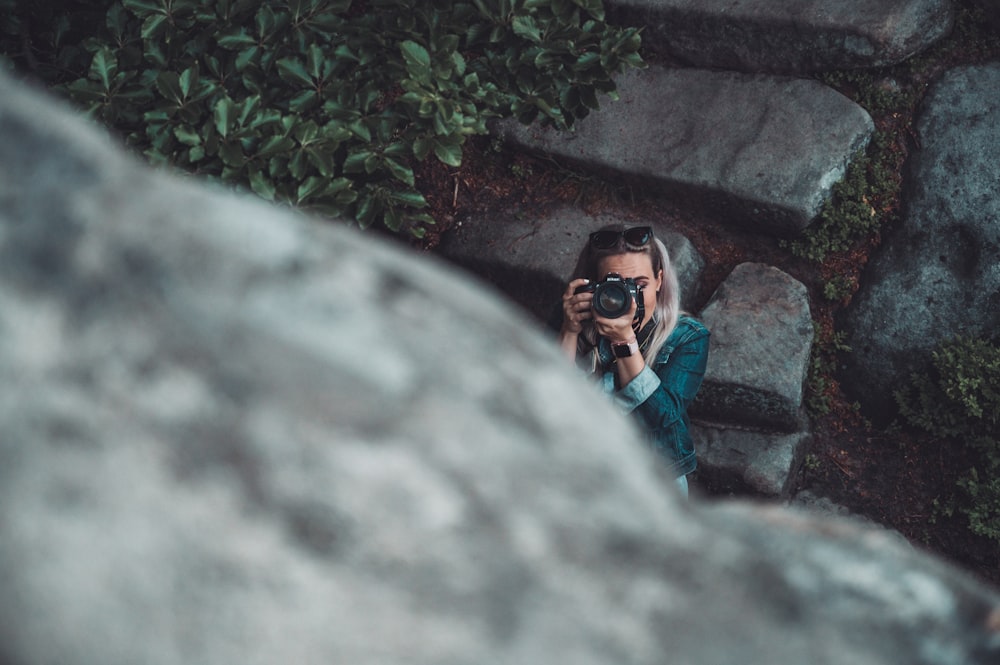 woman holding black DSLR camera