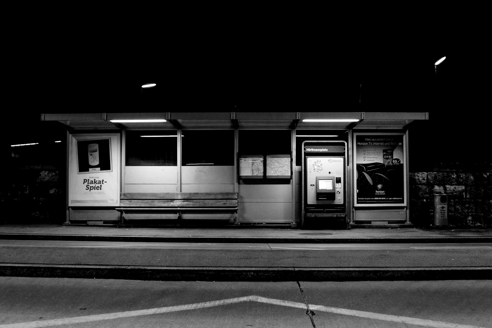 A grey concrete transit terminal building photographed in monochrome