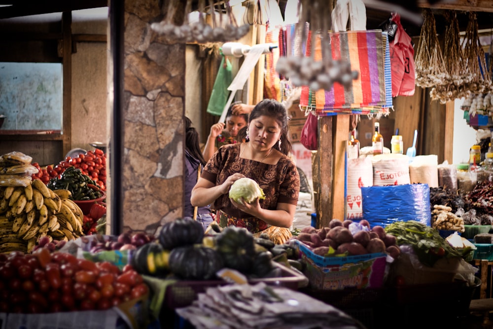 野菜売り場の近くに座る女性