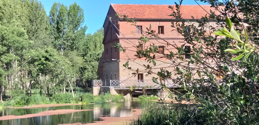 brown three-storey brick house by the lake