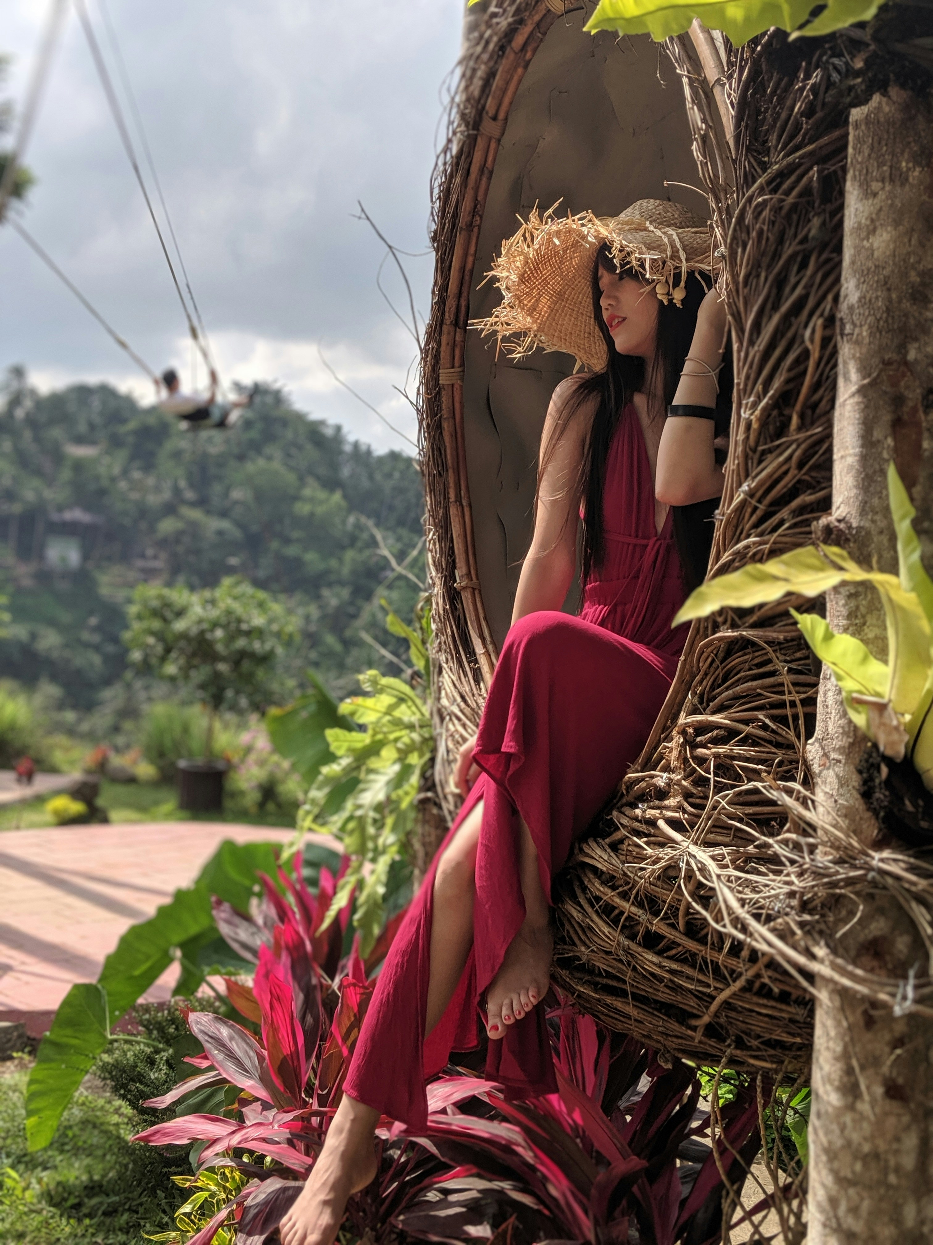 woman sitting on brown hanging chair making a pose