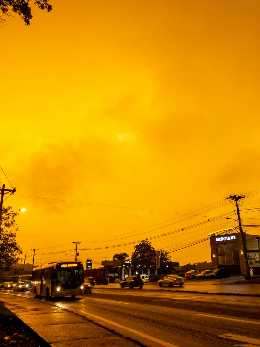 cars and buses traveling on highway under yellow sunset sky