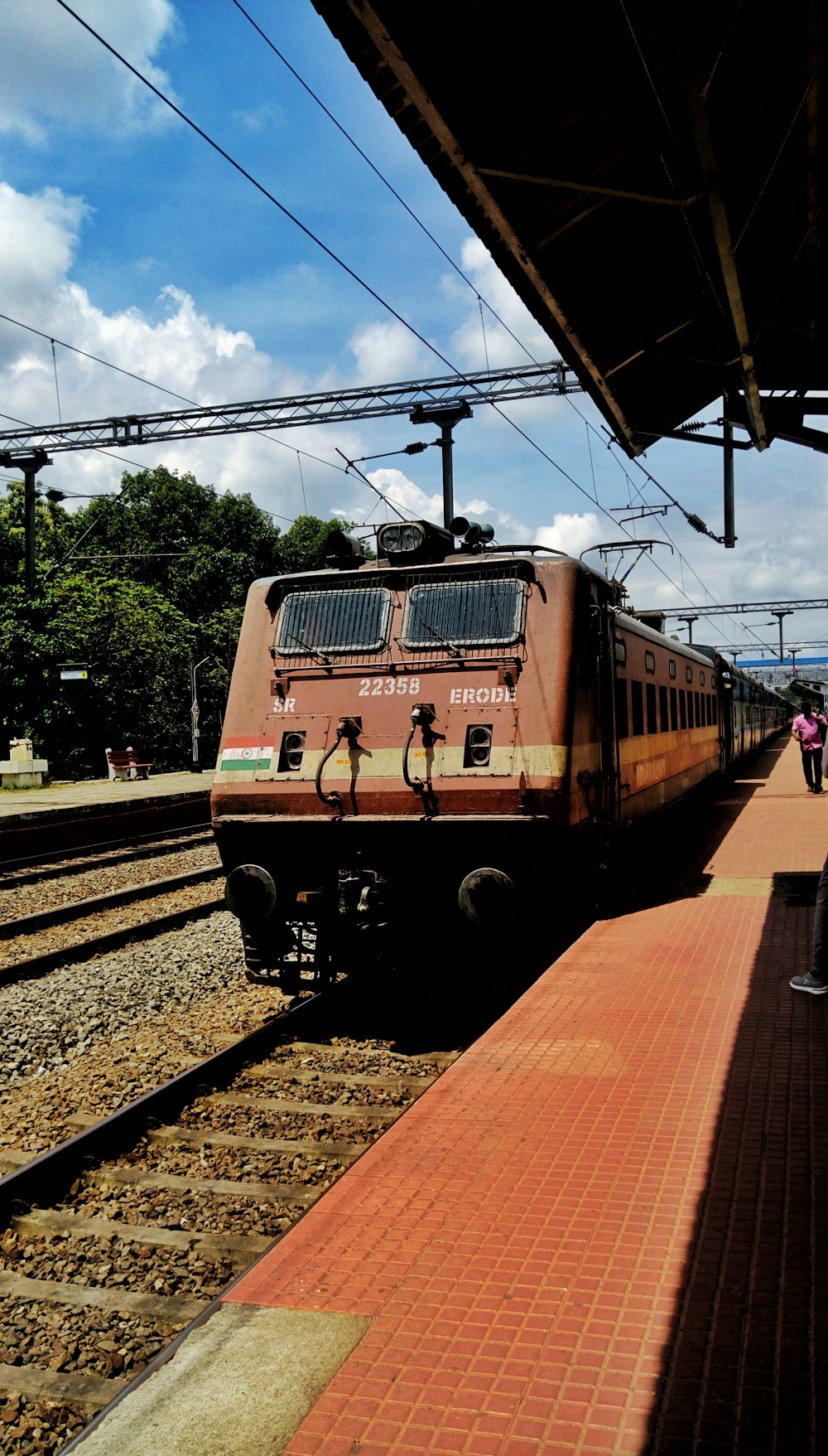 few people on train station under white and blue skies