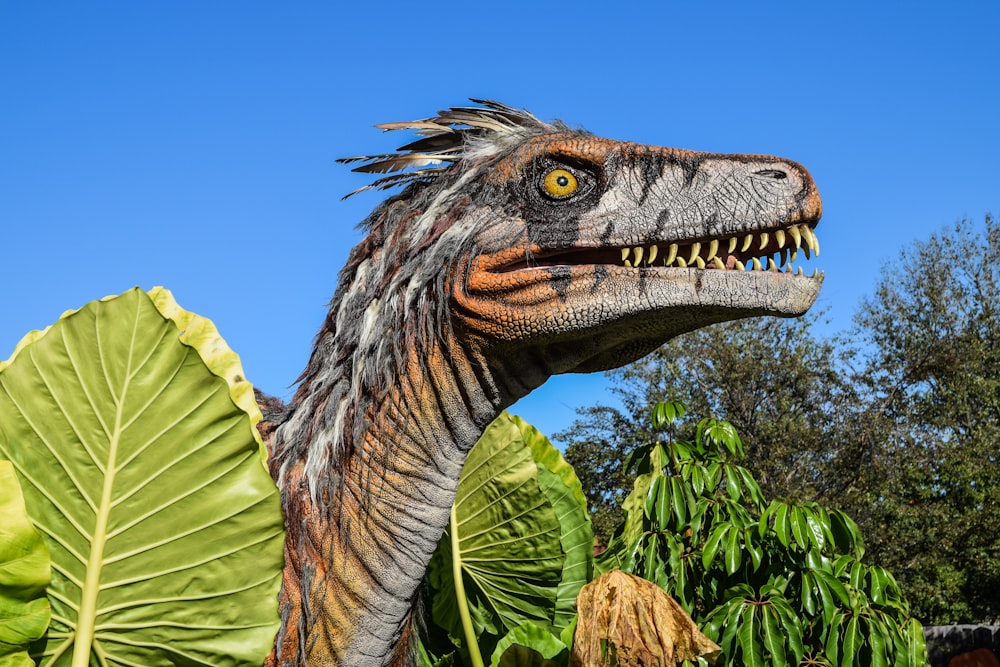 Dinosaurio gris y marrón rodeado de árboles durante el día