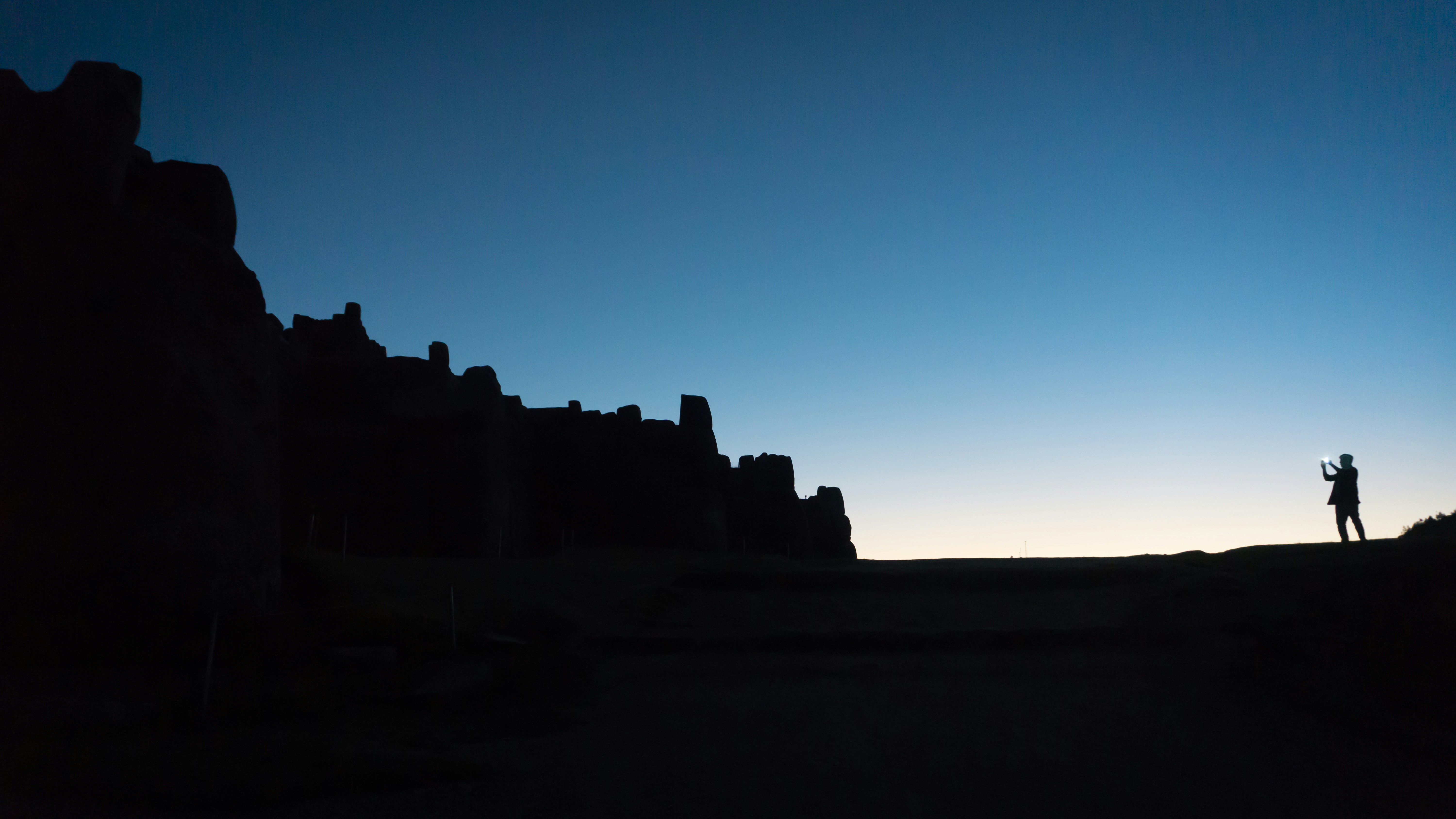 A person taking photos to ruins in Cusco, Peru.